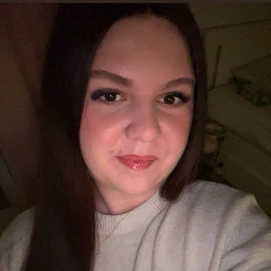 Porträt einer Frau mit dunklem Haar und freundlichem Lächeln.